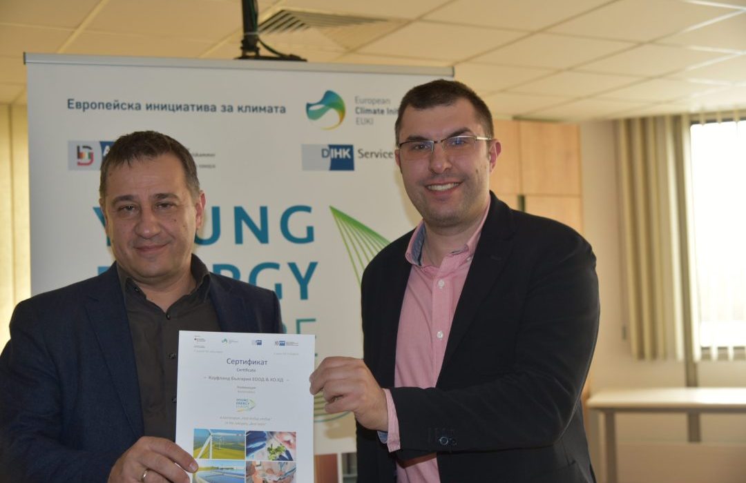 Two men hold a certificate, in the background and on the certificate you can see logos of "Young Energy Europe".