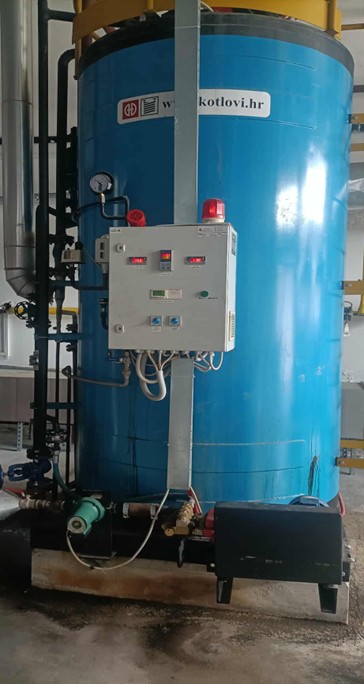 In the picture you can see a blue machine in a factory, called a steam bouiler.